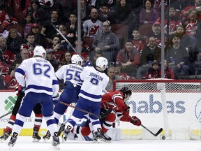 New Jersey Devils center Nico Hischier, right, of Switzerland, scores a goal on the Tampa Bay Lightning during the first period of an NHL hockey game, Saturday, March 24, 2018, in Newark, N.J.