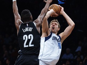 Dallas Mavericks' Dirk Nowitzki (41) shoots next to Brooklyn Nets' Caris Levert (22) during the first half of an NBA basketball game, Saturday, March 17, 2018, in New York.