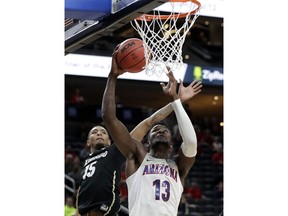 Colorado's Dominique Collier, left, covers a shot from Arizona's Deandre Ayton during the first half of an NCAA college basketball game in the quarterfinals of the Pac-12 men's tournament Thursday, March 8, 2018, in Las Vegas.