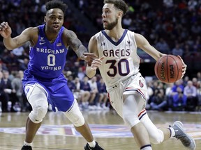 Saint Mary's Jordan Ford (30) drives past BYU's Jahshire Hardnett during the first half of a West Coast Conference tournament NCAA college basketball game, Monday, March 5, 2018, in Las Vegas.