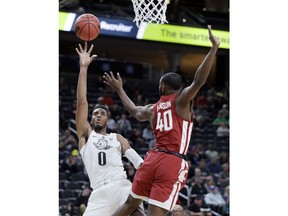 Oregon's Troy Brown, left, shoots while covered by Washington State's Kwinton Hinson during the first half of an NCAA college basketball game in the first round of the Pac-12 men's tournament Wednesday, March 7, 2018, in Las Vegas.