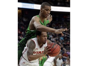Oregon's Kenny Wooten, top, and Utah's Justin Bibbins reach for a loose ball during the first half of an NCAA college basketball game in the quarterfinals of the Pac-12 men's tournament Thursday, March 8, 2018, in Las Vegas.