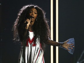 FILE - In this Jan. 28, 2018 file photo, Sza performs "Broken Clocks" at the 60th annual Grammy Awards at Madison Square Garden in New York.  SZA didn't let a torn ligament in her foot slow her down at a concert for her feverish fans in New York City. She walked into the venue Friday, March 16 with a crutch helping her to the chair placed in the middle of the stage for her comfort. She injured her foot while performing last week at the BUKU Music + Art Project festival in New Orleans.