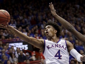 FILE - In this Jan. 2, 2018, file photo, Kansas' Devonte' Graham puts up a shot during the first half of an NCAA college basketball game against Texas Tech, in Lawrence, Kan. Graham was named the Big 12 player of the year, Tuesday, March 6, 2018.