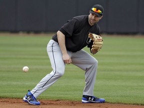 FILE - In this Feb. 27, 2018, file photo, Major League Baseball free agent second baseman Neil Walker fields a ground ball during infield drills before a scrimmage game  in Bradenton, Fla. A person familiar with the negotiations says free agent infielder Neil Walker and the New York Yankees are close to an agreement on a one-year contract for about $5 million. The person spoke to The Associated Press on condition of anonymity Monday, March 12, 2018, because an agreement would be subject to a successful physical.
