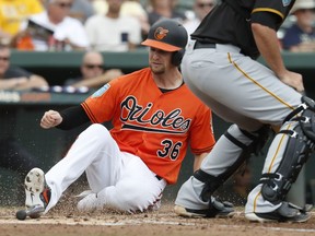 FILE - In this March 2, 2018, file photo, Baltimore Orioles' Caleb Joseph scores on a two-run single by Trey Mancini in the fourth inning of a spring training baseball game against the Pittsburgh Pirates, in Sarasota, Fla. Two years ago, Orioles catcher Caleb Joseph went through an entire season without an RBI. He rebounded last season, and now he's working as a starting catcher for the first time in his career.