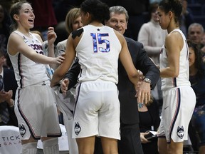 FILE - In this Feb. 26, 2018, file photo, Connecticut head coach Geno Auriemma, center, and player Katie Lou Samuelson, left, smile as seniors Gabby Williams, center, and Kia Nurse leave play for the final time in regular season play during the second half an NCAA college basketball game against South Florida, in Storrs, Conn. UConn finishes No. 1 in The Associated Press women's basketball poll for the fifth straight year. The Huskies (32-0) enter the NCAA Tournament as the lone unbeaten team and went wire-to-wire as the unanimous top team. They received all 32 votes from the national media panel Monday, March 12, 2018.
