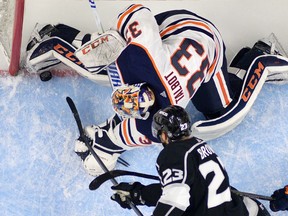 FILE - In this Feb. 24, 2018, file photo, Los Angeles Kings right wing Dustin Brown, below, puts the puck over the line past Edmonton Oilers goaltender Cam Talbot with seconds to go in the third period of an NHL hockey game in Los Angeles. The goal was called back for goalie interference. The Oilers won 4-3. The league's general managers recommended shifting the decision on a coach's challenge for goalie interference from on-ice officials to the league's situation room in Toronto. The board of governors and NHL/NHL Players' Association competition committee must approve the change for it to go into effect.