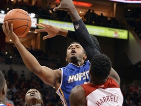 FILE - In this Nov. 12, 2013, file photo, Hofstra's Zeke Upshaw attempts a shot over the defense of Louisville's Montrezl Harrell (24) during the first half of an NCAA college basketball game, in Louisville, Ky. A Detroit Pistons developmental player who collapsed Saturday night on the court during a NBA G League game against the Long Island Nets in Michigan, has died. The Grand Rapids Drive says 26-year-old Zeke Upshaw died at a hospital Monday, March 26, 2018.