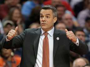 FILE - In this March 16, 2018, file photo, Virginia coach Tony Bennett signals for a jump ball during the first half of the team's first-round game against UMBC in a men's college basketball tournament in Charlotte, N.C. Bennett was named The Associated Press NCAA college basketball Coach of the Year, Thursday, March 29, 2018.