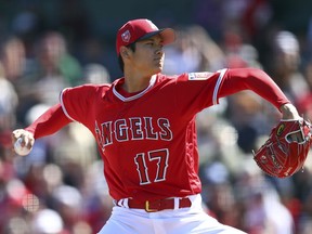 FILE - In this Feb. 24, 2018, file photo, Los Angeles Angels' Shohei Ohtani works against the Milwaukee Brewers during the first inning of a spring training baseball game, in Tempe, Ariz. Ohtani is expected to start the season in the Angels' specially designed six-man rotation. Los Angeles also plans to use Ohtani as its designated hitter for a couple of days in between his starts, providing ample opportunity for the 23-year-old phenom to adjust to the speed and quirks of the big-league game.