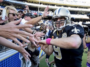 FILE - In this Oct. 2, 2016, file photo, New Orleans Saints quarterback Drew Brees reacts with fans after an NFL football game against the San Diego Chargers, in San Diego. A person familiar with the contract says Drew Brees has agreed to a two-year, $50 million extension with the New Orleans Saints. The person spoke to The Associated Press on condition of anonymity on Tuesday, March 13, 2018, because the agreement has not been announced.