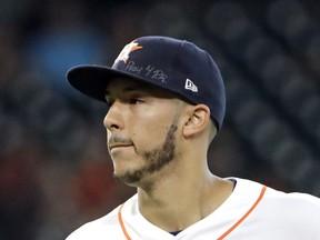 FILE - This is a Sept. 23, 2017, file photo showing Houston Astros shortstop Carlos Correa wears a message on his cap for those affected by the Hurricane in Puerto Rico during the second inning of a baseball game. Correa skipped the Astros' visit to the White House, Monday, March 12, 2018,  to help arrange for more relief supplies for shipment to hurricane-ravaged Puerto Rico, where he grew up.