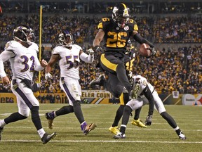 FILE - In this Dec. 25, 2016, file photo, Pittsburgh Steelers running back Le'Veon Bell (26) leaps into the end zone ahead of Baltimore Ravens strong safety Eric Weddle (32) for a touchdown during the second half of an NFL football game in Pittsburgh. The Steelers have put the franchise tag on All-Pro running back Le'Veon Bell for a second straight spring, putting his long-term status with the club up in the air.