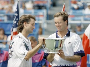 FILE - In this Sept. 10, 1993, file photo, Ken Flach, left, of Alpharetta, Ga., and Rick Leach, right, of Laguna Beach, Calif., check out the winner's trophy after taking the U.S. Open men's doubles title in New York. Flach, who won four Grand Slam titles in men's doubles and two in mixed doubles, died Monday night, March 12, 2018, in California after a brief illness, the ATP World Tour and International Tennis Federation announced Tuesday, March 13, 2018. He was 54.