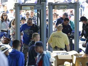 FILE - In this May 10, 2015, file photo, fans pass through metal detectors as they go through security procedures to enter Safeco Field for a baseball game between the Seattle Mariners and the Oakland Athletics in Seattle. Atlanta, Oakland and Seattle will open express entrances to members of CLEAR, expanding the fast-entry lanes to nine of the 30 big league ballparks. CLEAR is available at 24 U.S. airports to speed passage through security.