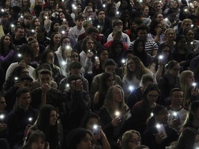 FILE - In this Wednesday, March 14, 2018 file photo, students hold their lighted cellphones at a rally at Parkland High School outside Allentown, Pa. Hundreds of students at Parkland walked out of class and headed to the auditorium for the #parklandforparkland rally, which was held to protest gun violence in response to last month's massacre of 17 people at Marjory Stoneman Douglas High School, in Parkland, Fla.