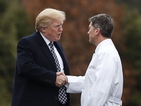 In this Friday, Jan. 12, 2018 file photo, President Donald Trump shakes hands with White House physician Dr. Ronny Jackson as he boards Marine One to leave Walter Reed National Military Medical Center in Bethesda, Md.