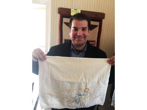 CORRECTS DAY OF AUCTION TO MARCH 8 FROM MARCH 9 - This undated photo provided by Adam Sackowitz, of Queens, New York, shows him displaying an embroidered pillowcase with celestial bodies on it that belonged to the late John Glenn. Sackowitz purchased the pillowcase for $2,500 at a March 8, 2018, estate sale in Potomac, Md. He hopes to donate it to a historic site in Glenn's native Ohio. (Courtesy of Adam Sackowitz via AP)