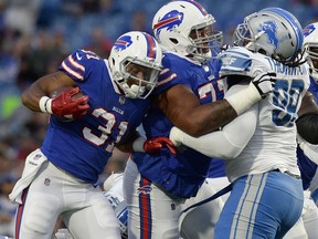 FILE - In this Aug. 31, 2017, file photo, Buffalo Bills running back Jonathan Williams (31) follows the block of tackle Cordy Glenn (77) against Detroit Lions defensive tackle Khyri Thornton (99) during the first half of a preseason NFL football game in Orchard Park, N.Y. A person familiar with the deal has told The Associated Press the Bills have moved up nine spots in the draft by swapping first-round draft picks with the Cincinnati Bengals, who also acquired high-priced left tackle Glenn as part of the trade.