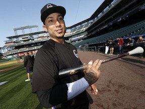 FILE - In this Sept. 29, 2017, file photo, Colorado Rockies right fielder Carlos Gonzalez heads back to the dugout after warming up for a baseball game against the Los Angeles Dodgers in Denver. The Rockies finalized a $5 million, one-year deal to bring back three-time All-Star and popular clubhouse leader Gonzalez. His agreement was announced Monday, March 12, 2018, and includes $3 million in bonuses based on days on the active roster.