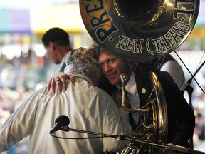 FILE - In this May 6, 2012, file photo, Ben Jaffe, tuba player and director of the Preservation Hall Jazz Band hugs George Wein, founder of the New Orleans Jazz and Heritage Festival, as well as the Newport Jazz Festival, after Wein performed a song on the piano at the New Orleans Jazz and Heritage Festival in New Orleans. Someone has stolen Preservation Hall's signature sousaphone, and there's a reward offered for its return. Jaffe posted a message about the theft on the jazz venue's Facebook page, saying it was stolen after a performance Saturday, Feb. 24, 2018.