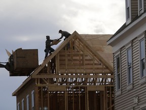 In this Feb. 26, 2018, photo, construction workers work on a new townhouse in Wood-Ridge, N.J. On Thursday, March 1, 2018, the Commerce Department reports on U.S. construction spending in January.