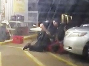FILE - In this July 5, 2016 image made from video, Alton Sterling is restrained by two Baton Rouge police officers, one holding a gun, outside a convenience store in Baton Rouge, La. Moments later, one of the officers shot and killed Sterling, a black man who had been selling CDs outside the store, while he was on the ground. Louisiana's attorney general has ruled out criminal charges against the two white officers in the fatal shooting of Sterling.