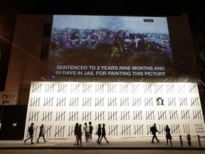 People pass by a mural by British graffiti artist Banksy protesting the imprisonment of Turkish artist Zehra Dogan Friday, March 16, 2018, in New York. Banksy has created the New York mural protesting the imprisonment of Dogan, an ethnic Kurd jailed after painting the Turkish flag flying over the rubble of a destroyed town.