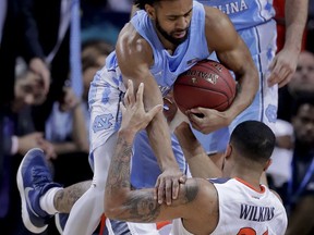 North Carolina guard Joel Berry II (2) becomes entangled with Virginia forward Isaiah Wilkins (21) while scrambling for the ball in the first half of an NCAA college basketball game during the championship game of the Atlantic Coast Conference men's tournament Saturday, March 10, 2018, in New York.