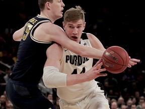 Purdue center Isaac Haas (44) drives against Michigan center Jon Teske (15) during the first half of the Big Ten Conference tournament championship NCAA college basketball game, Sunday, March 4, 2018, in New York.