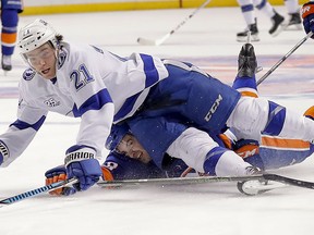 Tampa Bay Lightning center Brayden Point (21) hits the ice on a breakaway as he is tripped by New York Islanders defenseman Adam Pelech (50) during the first period of an NHL hockey game Thursday, March 22, 2018, in New York.