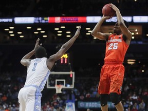 Syracuse guard Tyus Battle (25) shoots over North Carolina forward Theo Pinson (1) during the first half of an NCAA college basketball game in the second round of the Atlantic Coast Conference men's tournament Wednesday, March 7, 2018, in New York.