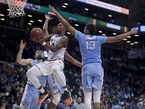 Miami guard Lonnie Walker IV (4) shoots against North Carolina guard Cameron Johnson (13) during the second half of an NCAA college basketball game in the Atlantic Coast Conference men's tournament Thursday, March 8, 2018, in New York.