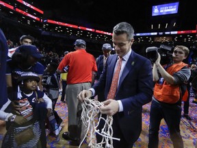 Virginia coach Tony Bennett walks off the floor with one of the nets after Virginia defeated North Carolina 71-63 in an NCAA college basketball game for the Atlantic Coast Conference men's tournament title Saturday, March 10, 2018, in New York.