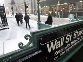 FILE- In this March 14, 2017, file photo, morning commuters walk on Broadway in New York's Financial District. The U.S. stock market opens at 9:30 a.m. EST on Tuesday, March 6, 2018.