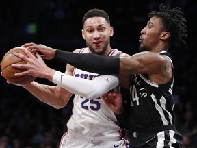 Brooklyn Nets forward Rondae Hollis-Jefferson, right, gets this hand on the ball as Philadelphia 76ers guard Ben Simmons, left, looks to pass during the first half of an NBA basketball game, Sunday, March 11, 2018, in New York.