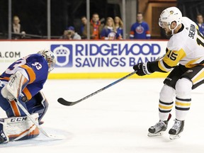 New York Islanders goaltender Christopher Gibson (33) of Finland makes a save on a shot by Pittsburgh Penguins center Riley Sheahan (15) during the first period of an NHL hockey game in New York, Tuesday, March 20, 2018.