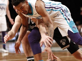 Charlotte Hornets forward Dwayne Bacon, right, and Brooklyn Nets forward Joe Harris go after a loose ball beneath the Hornets basket during the first half of an NBA basketball game Wednesday, March 21, 2018, in New York.