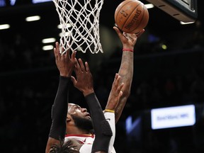 Cleveland Cavaliers forward LeBron James, right,  drives for a layup as Brooklyn Nets forward Rondae Hollis-Jefferson (24) defends during the first half of an NBA basketball game, Sunday, March 25, 2018, in New York.