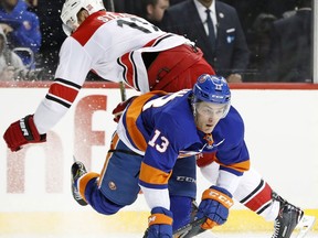 Carolina Hurricanes center Jordan Staal (11) trips over New York Islanders center Mathew Barzal (13) during the first period of an NHL hockey game in New York, Sunday, March 18, 2018.