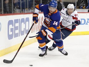 Washington Capitals right wing T.J. Oshie (77) gets his stick out in front of New York Islanders defenseman Thomas Hickey (14) during the third period of an NHL hockey game in New York, Thursday, March 15, 2018. The Capitals defeated the Islanders 7-3.