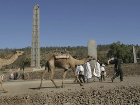 FILE - In this April 2, 2005, file photo, local Ethiopian farmers and their camels walk past the Obelisk steles area in Axum. The blockbuster film "Black Panther" has created a new compelling vision of Africa as a continent of smart, technologically savvy people with cool clothes living in a futuristic city amid stunning landscapes.