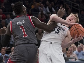 St. John's guard Bashir Ahmed (1) guards Xavier guard J.P. Macura (55) during the first half of an NCAA college basketball game in the quarterfinals of the Big East conference tournament, Thursday, March 8, 2018, at Madison Square Garden in New York.