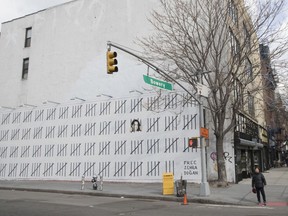 A pedestrian walks past a mural by British artist Banksy protesting the imprisonment of Turkish artist Zehra Dogan, Friday, March 16, 2018, in New York.