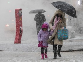 Pedestrians walk along Delancey St. during a snowstorm, Wednesday, March 7, 2018, in New York. The New York metro area was hit with another winter storm Wednesday just days after another nor'easter hammered the region with high winds.