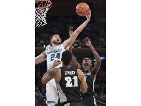 Creighton guard Mitch Ballock (24) fights for a rebound against Providence guard Jalen Lindsey (21) and forward Rodney Bullock (5) during the first half of an NCAA college basketball game in the quarterfinals of the Big East conference tournament, Thursday, March 8, 2018, at Madison Square Garden in New York.