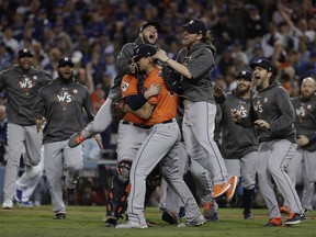 FILE - In this Nov. 1, 2017 file photo the Houston Astros celebrate after Game 7 of baseball's World Series against the Los Angeles Dodgers in Los Angeles. Rebuilding _ or, to use the less euphemistic term, tanking _ has become one of baseball's most polarizing topics in 2018. When the Astros won the World Series last season, four years after a 111-loss debacle, they became a shining example of how short-term pain can lead to long-term gain, but as other teams try to follow Houston's lead, they're being met with varying degrees of skepticism.