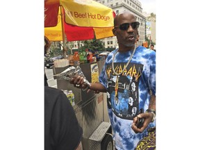 In this August 2017 photo, DMX, the rapper also known as Earl Simmons, buys a hot dog at a car outside of Manhattan federal court in New York after an appearance in his tax fraud case. DMX could get up to five years in prison when he is sentenced, Wednesday, March 28, 2018, for trying to dodge $1.7 million in taxes.