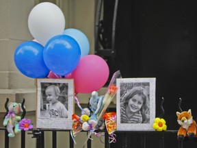 FILE - In this Oct. 27, 2012, file photo, photographs of 6-year-old Lucia Krim and her 2-year-old brother, Leo, are displayed alongside balloons and stuffed animals at a memorial outside the apartment building where they lived in New York. Opening arguments begin Thursday, March 1, 2018, for Yoselyn Ortega, the family's nanny charged with murder in the Oct. 25, 2012, deaths of the siblings.
